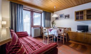 sala de estar con mesa y comedor en Residence A Val, en San Cassiano