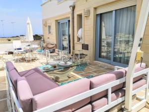 a balcony with pink furniture and a table at Le Terrazze in Otranto