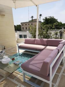 un sofá púrpura en un patio con mesa en Le Terrazze, en Otranto