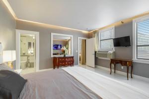 - une chambre avec un lit, un bureau et une télévision dans l'établissement ORCHID SUITES - Historic Palm Beach Hotel Condominium, à Palm Beach