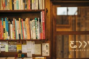 a book shelf filled with lots of books at Torii-Kuguru in Okayama