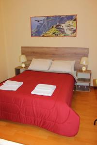 1 dormitorio con 1 cama roja y 2 lámparas en Holidays Hostel Arequipa en Arequipa