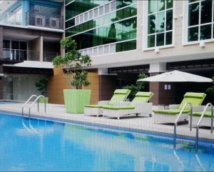 a swimming pool with chairs and umbrellas next to a building at Fantastic Affordable high end condominium heart of the Cebu city in Cebu City