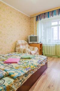 um quarto com uma cama, uma televisão e uma janela em Квартира по улице Лескова, 6 em Kiev