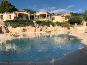 a pool of water in front of some houses at Wind Rose Exclusive -Natural pool 50 m from the Sea in Olbia