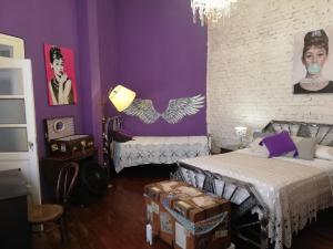 um quarto com duas camas e uma parede roxa em Andiamo Guest House em Buenos Aires