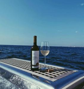 una botella de vino y una copa de vino en un barco en Porto Private Yacht- Accommodation Douro River en Oporto