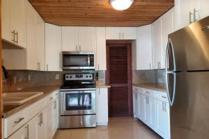 a kitchen with white cabinets and stainless steel appliances at Havensight Haven 1BR/1.5BA in Estate Thomas