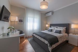 Schlafzimmer mit einem Bett, einem Schreibtisch und einem TV in der Unterkunft Terrace Apartment in Ponta Delgada