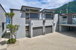 a house with two garage doors in a driveway at Lakeview 5BR Apartment Walk to Town in Queenstown
