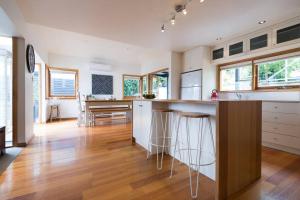a kitchen with white cabinets and a wooden floor at Best Location in Hobart! Luxury 4 bedroom with stunning views in Hobart