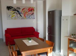 - un salon avec un canapé rouge et une table dans l'établissement il Terrazzo del Sole, à Alghero