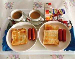 a tray with two plates of toast and hot dogs and coffee at Aiyapach Inn in Chon Buri