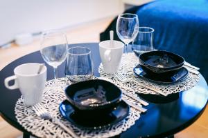 una mesa negra con vasos y platos. en Sou, en Fujisawa