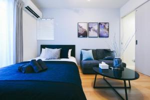 een slaapkamer met een blauw bed en een tafel bij Sou in Fujisawa