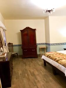 een slaapkamer met een bed en een houten dressoir bij Casa Tía Anita, Hotel Boutique in Mascota