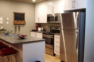 una cocina con nevera de acero inoxidable y armarios blancos en 1-Bedroom Apartment Bellisimo AG by Amazing Property Rentals, en Gatineau