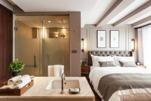 um quarto com uma cama, um lavatório e um chuveiro em Marine Beach Hotel Pattaya - SHA Plus em Praia de Jomtien