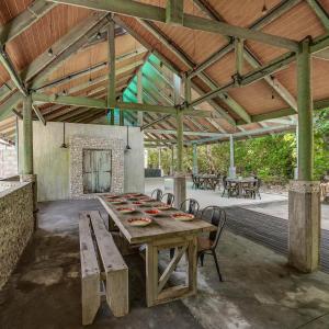 a wooden table in a pavilion with a table and chairs at Mi Lugar Maldives in Nolhivaranfaru