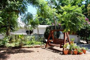a wooden swing in a garden with plants at Nuwerus Lodge Paarl in Paarl