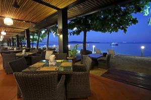 un restaurante con mesas y sillas y vistas al agua en Queenco Hotel & Casino, en Sihanoukville