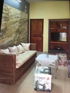 uma sala de estar com um sofá, uma mesa e uma televisão em Vicky Appartements Palmengarten Douala Maképè Belavie em Douala