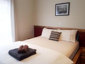 a bedroom with two beds with slippers on them at Couples Retreat with Mountain View Near Hobart in Sandford