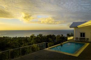 a villa with a swimming pool and a view of the ocean at Pacific View Dalaguete in Dalaguete