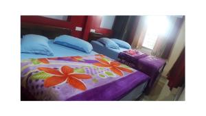 1 dormitorio con cama con colcha de flores en WILLOW HILL LEISURE HOME, en Munnar