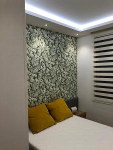 a bedroom with a wall with a painting on it at GOMAX Apartmani Zlatibor in Zlatibor