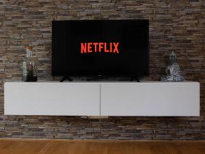 a television on top of a white tv stand in front of a brick wall at Apartment Mama Lisa in Lauterach