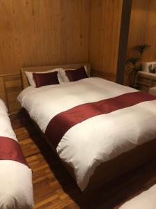 a bedroom with two beds with white and red sheets at sakura.nagoya in Nagoya