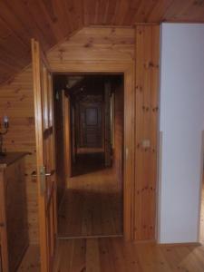 a hallway in a log cabin with a door open at Pension Cortina in Pec pod Sněžkou