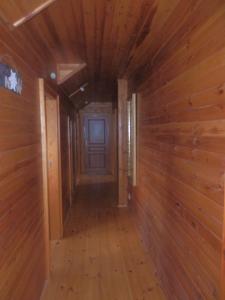 a hallway in a cabin with wooden walls and a door at Pension Cortina in Pec pod Sněžkou