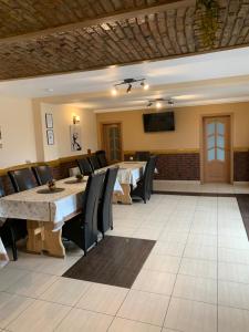 a dining room with a table and chairs and a television at Pensiunea Haiduc Sacele Brasov in Săcele