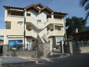 a large white building with a stone wall at Apartments 2 Ivanković in Stari Grad