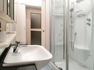 biała łazienka z umywalką i prysznicem w obiekcie Vistalago 55 w Como