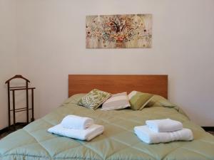 łóżko z dwoma białymi ręcznikami na górze w obiekcie Vistalago 55 w Como