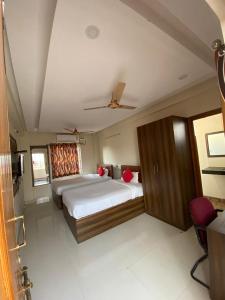 a bedroom with a large bed and a ceiling at Hotel Renuka in Visakhapatnam