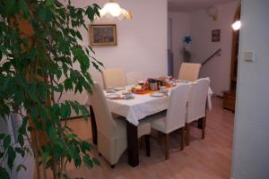 a dining room table with a white tablecloth and white chairs at Sebastiana's FeWo in Merzig +17 photos