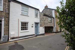 a white building with a blue door on a street at Gelly Cott in Padstow