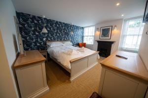 a bedroom with a bed and a desk and a fireplace at Gelly Cott in Padstow