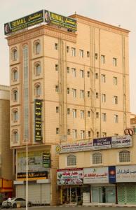 un grande edificio con un cartello sopra di Rimal Suites Apartments a Salalah