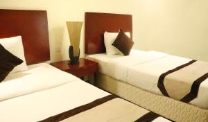 a hotel room with two beds and a table at Rimal Suites Apartments in Salalah