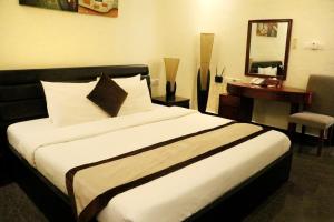a bedroom with a bed with a mirror and a table at Rimal Suites Apartments in Salalah
