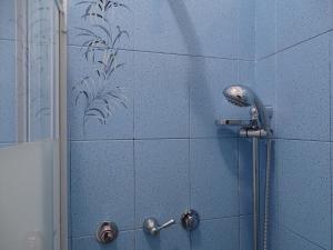 e bagno con piastrelle blu e doccia. di Bnbook-Ughelli a Rho