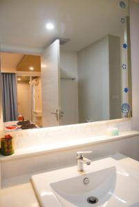 a bathroom with a sink and a large mirror at Seven Seas Resort Pattaya & Sofa bed in Jomtien Beach