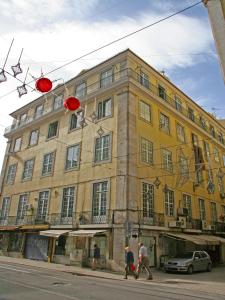 بينساو براكا دا فيغويرا في لشبونة: مبنى اصفر كبير فيه ناس تمشي امامه