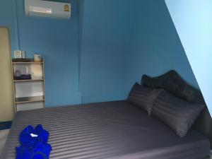 a blue bedroom with a bed with blue walls at Bangkado Resort in Ratchaburi