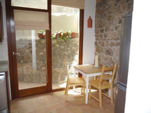 une cuisine avec une table et des chaises ainsi qu'un mur en pierre dans l'établissement Casa Vell de Valldemossa, à Valldemossa